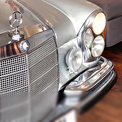 Nahaufnahme der Front eines silbernen Mercedes Oldtimers in der Mercedes Suite des V8 Hotels Böblingen. 