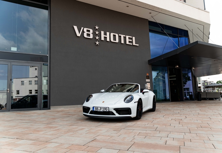 Porsche stands in front of building 