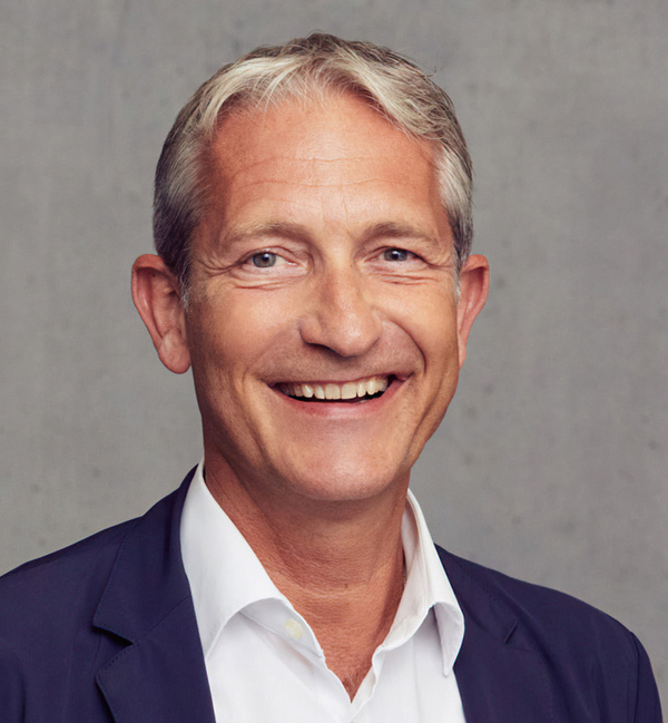 Simeon Schad, Geschäftsführer des V8 Hotels. Der Hintergrund ist hell und schlicht. Seine Ausstrahlung wirkt freundlich und offen.