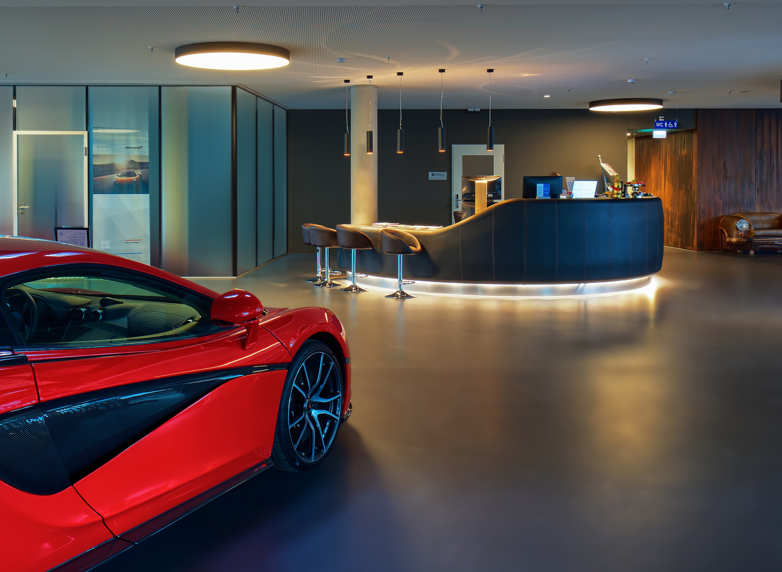 Rotes Auto in der Hotel-Lobby mit runder beleuchteter Rezeption