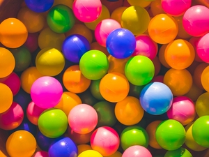Viele bunte Plastikbälle in Orange, Gelb, Blau, Grün und Pink