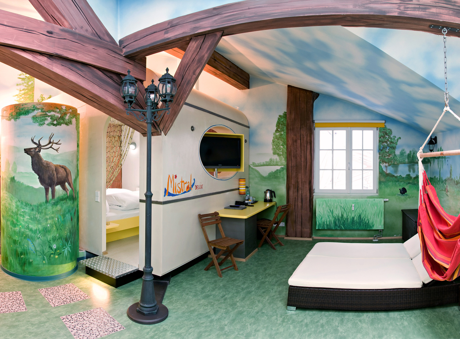 Großzügiges Zimmer mit zwei Schlafzimmer eingerichtet im Camping-Design mit Laterne und aufgemalten Holzbalken