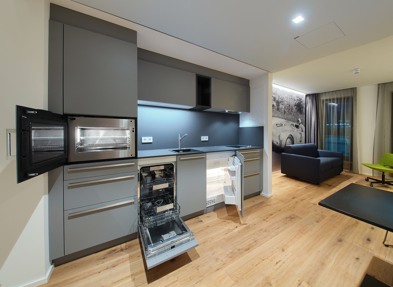 Einblick in die Küche des Serviced Appartements ausgestattet mit Backofen, Spülmaschine und Kühlschrank