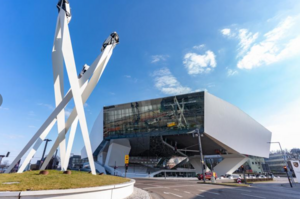 Außenansicht des Porsche Museums in Stuttgart mit dem markanten weißen Gebäude und der spiegelnden Glasfassade.