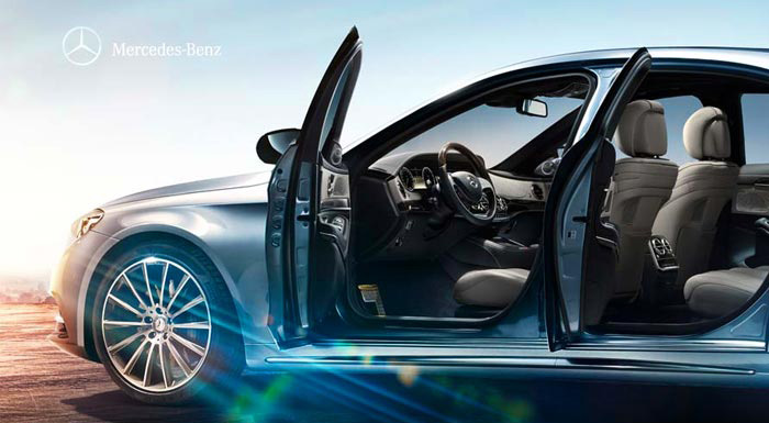 Das Bild zeigt das Innere eines Mercedes-Benz-Fahrzeugs mit offenen Türen. Der Innenraum ist modern und elegant gestaltet, mit beigen Sitzen und einem stilvollen Armaturenbrett. Der Fokus liegt auf der geräumigen und komfortablen Atmosphäre des Fahrzeugs.
