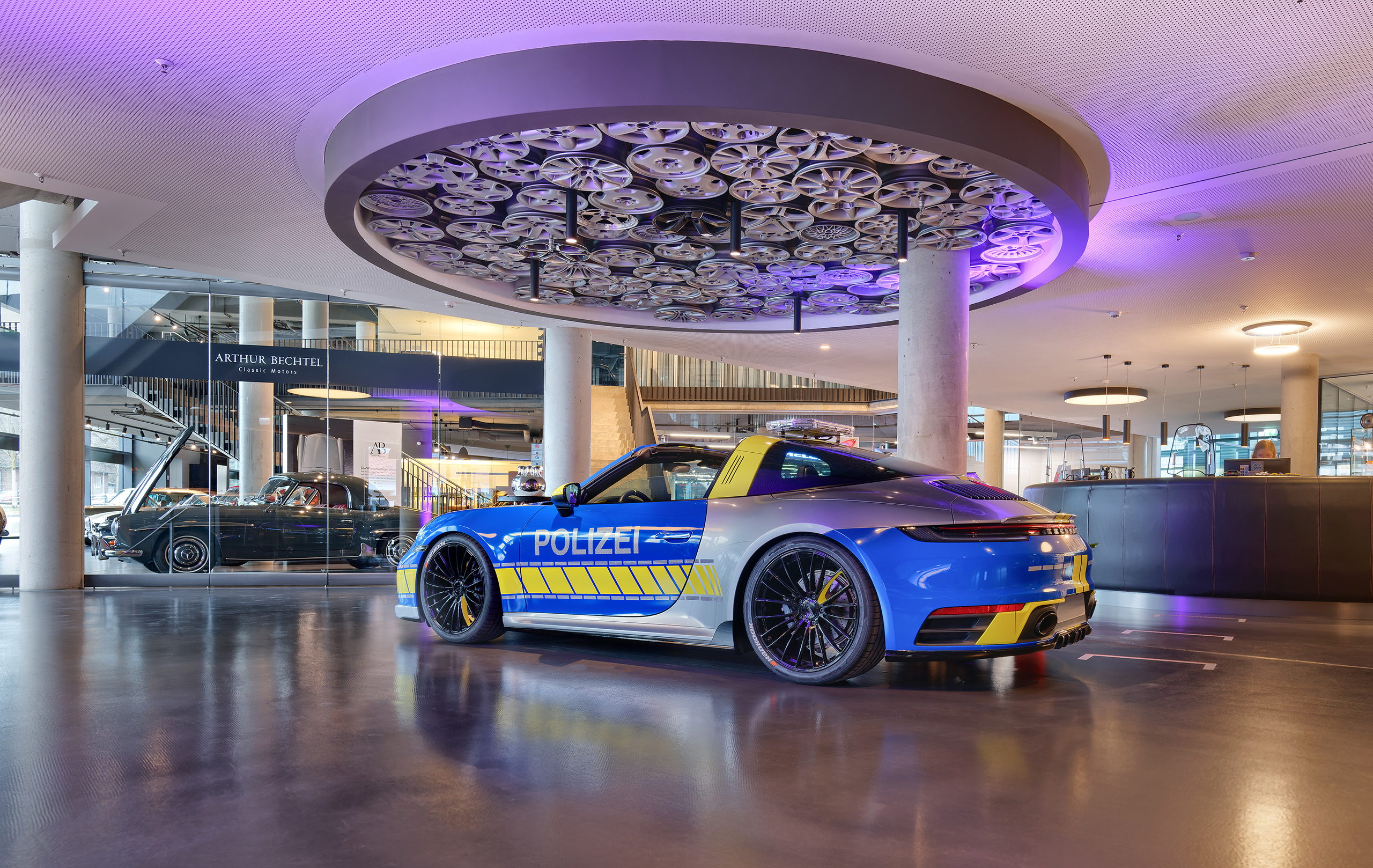 Porsche Polizeiauto in der Lobby vor der runden Rezeption